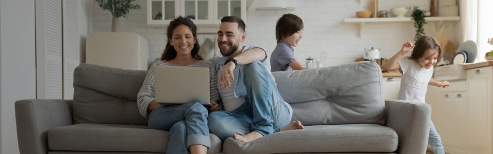 Fröhliche Familie beim Spielen und Lachen im gemütlichen Wohnzimmer.