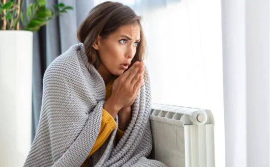 Stimmungsbild - Frau friert neben Heizung