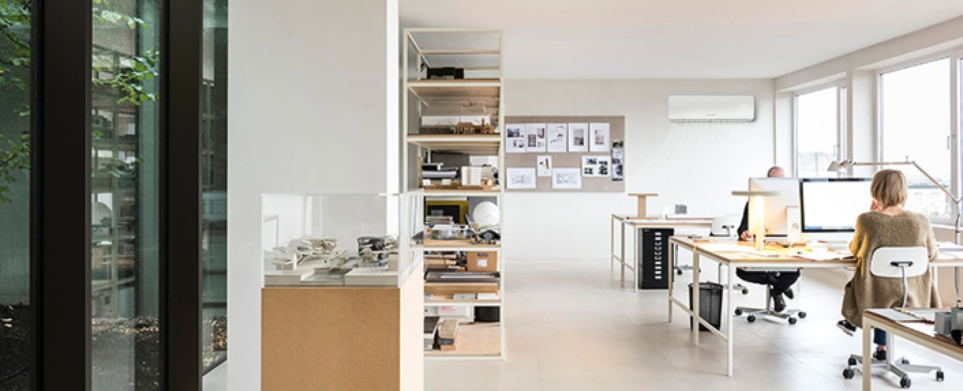 Helles Büro mit modernen Arbeitsplätzen, großen Fenstern und natürlicher Beleuchtung, ideal für produktives Arbeiten.